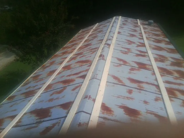 Rusted metal roof panels with new wood purlins before replacement — Storm Damage Roof Repair in Maybee by Roofing Brothers