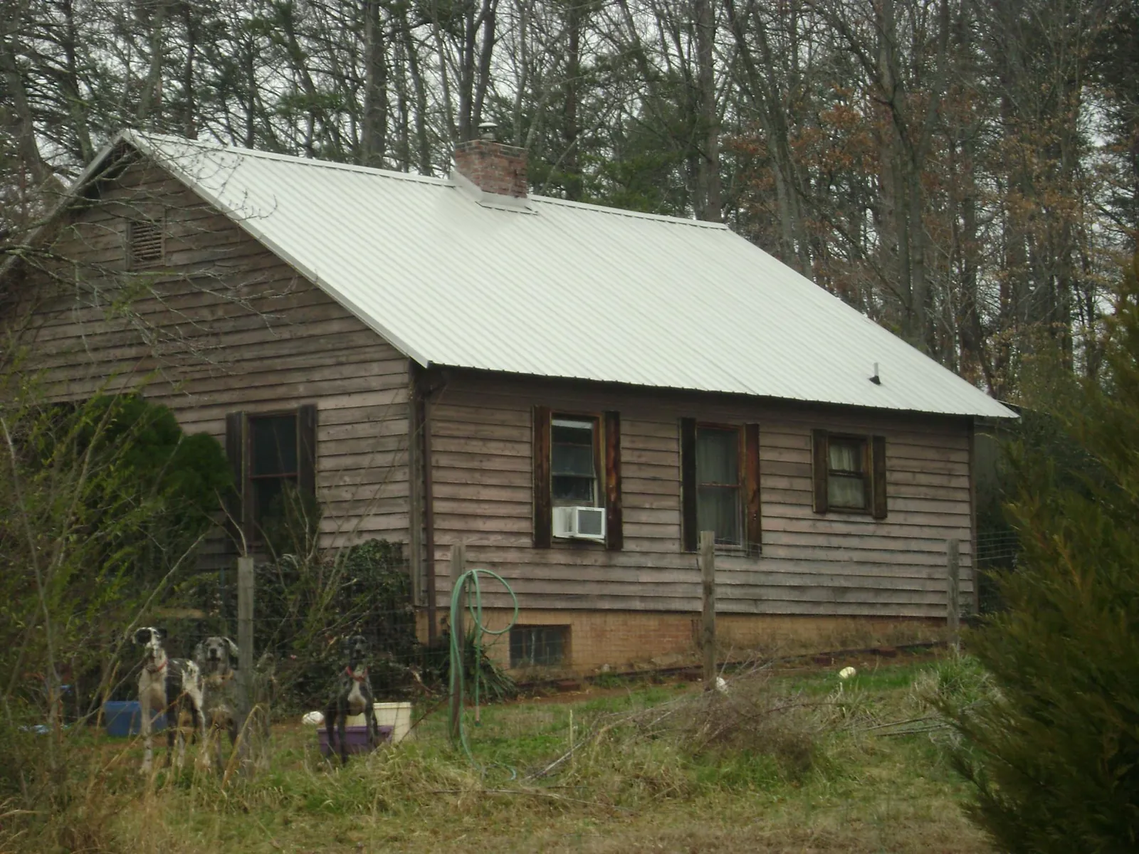 White metal roof on an old wood sided farmhouse, from a Metal Roof Installation job in Maybee